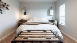 A bedroom with a bed, two bedside tables, a mirror, and a window with blinds. - Tacoma Dome condo w Mountn & Bay views + + PRK! (Tacoma)