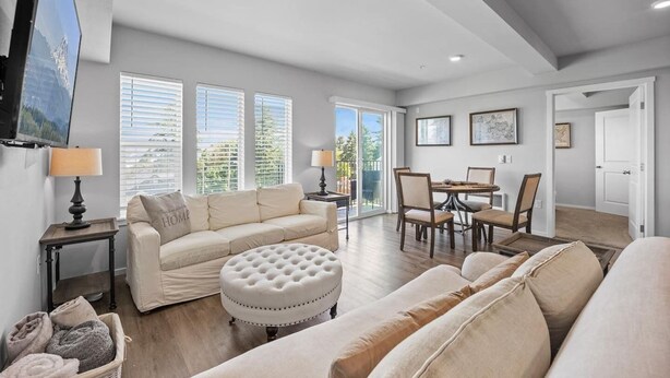 A spacious living room with a sofa, ottoman, and dining area. - Steps to Dome Breathtaking views + parking + AC! (Tacoma)