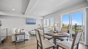A spacious living room with a round dining table, a sofa set, and a large window with a view. - Steps to Dome Breathtaking views + parking + AC! (Tacoma)