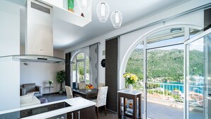 Una cocina moderna con una isla grande, un comedor con vistas y un balcón panorámico.