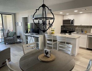 A modern kitchen with white cabinets, a granite countertop, and stainless steel appliances.