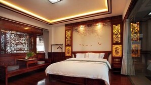 A traditional room with a large bed, wooden furniture, and decorative screens. - Yamingyuan Inn (Dali City)