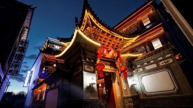 A traditional building with a curved roof, ornate decorations, and a large sign. - Yamingyuan Inn (Dali City)