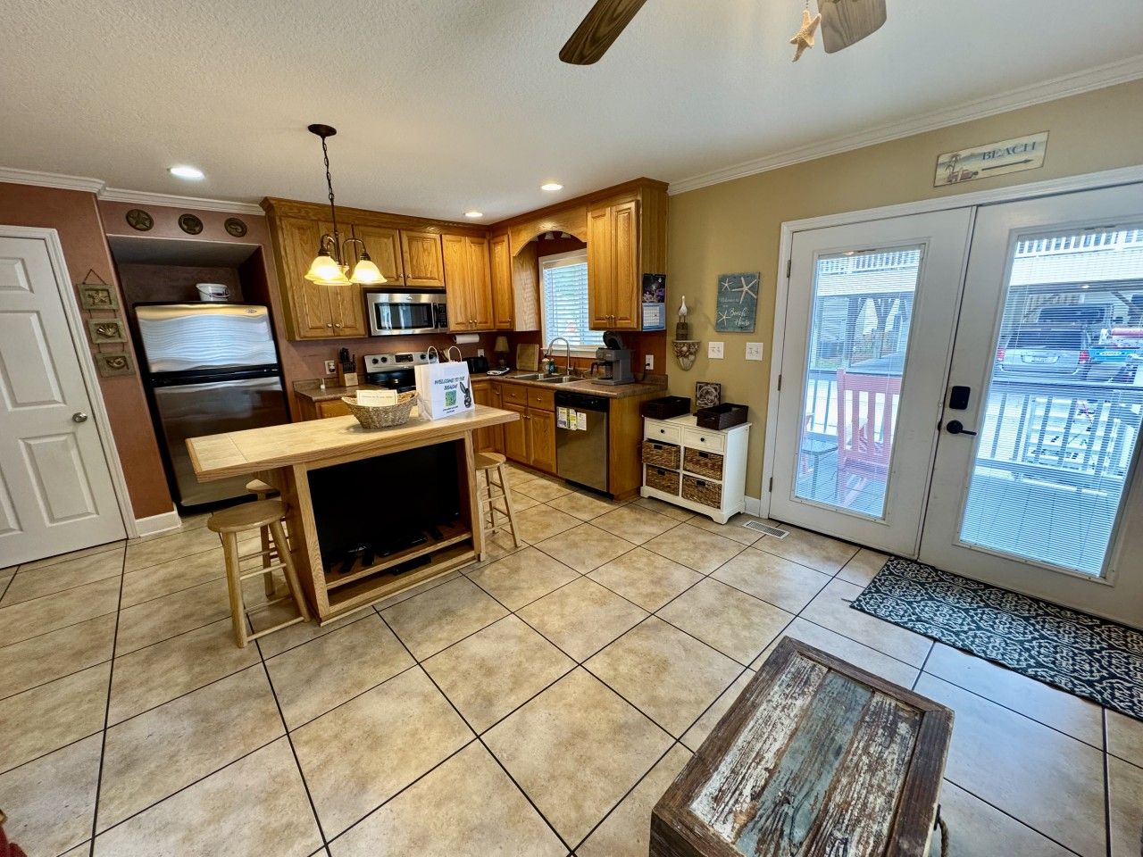 A kitchen with wooden cabinets, a built-in microwave, and a dining area with a bench.