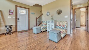 A spacious living room with hardwood floors, a staircase, and a decorative cabinet.