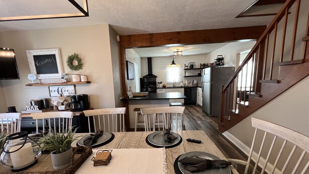 A modern kitchen with a dining area, wooden beams, and a staircase. - 7 mi to Grand Park, 1 mi to Mustard Seed, 5 min to downtown Noblesville! (Noblesville)