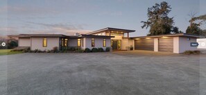 Ein modernes, zweistöckiges Haus mit großem Auffahrt, Garage und einem angelegten Vorgarten.