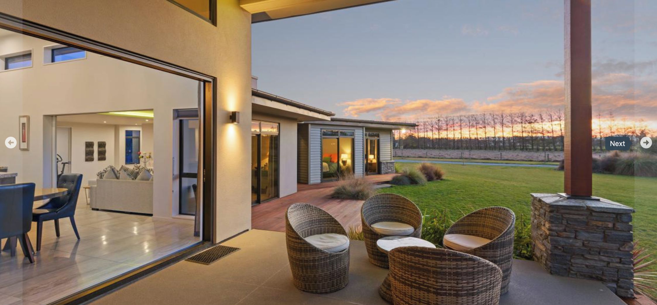 A modern house with a spacious patio, a dining area, and a view of the landscape.