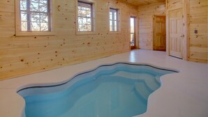 A room with wooden walls, a large indoor pool, and three windows. - New Built 2023- upscale, central location, Indoor pool (Pigeon Forge)