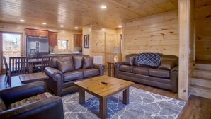 A log cabin interior with a living room, a kitchen, and a dining area. - New Built 2023- upscale, central location, Indoor pool (Pigeon Forge)
