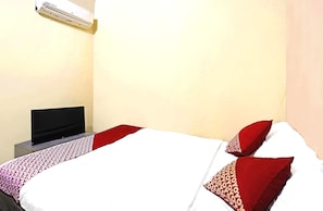 Une chambre d’hôtel équipée d’un lit, d’un téléviseur à écran plat et d’un climatiseur mural.