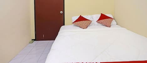 Habitación de hotel con una cama, una puerta y piso de baldosas.