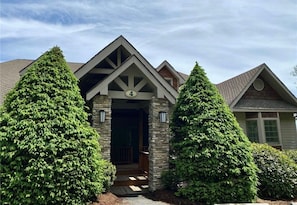 A house with a stone facade, a gabled roof, and a number '4' sign.