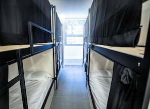A corridor with bunk beds, a window at the end, and a tiled floor. - MYD Madriz Hostel (Madrid)