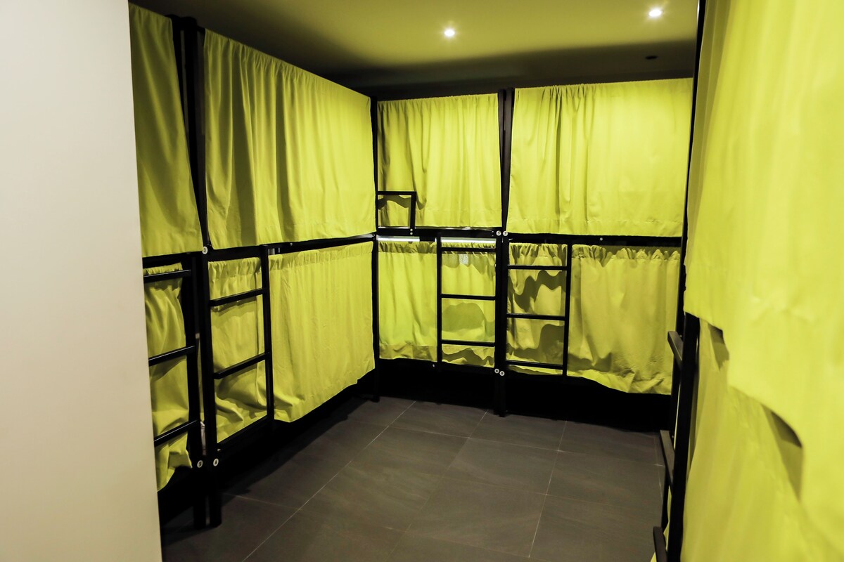 A room with a tiled floor and yellow curtains.