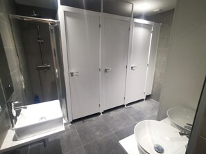 A modern bathroom with a large mirror, a sink, a bathtub, and a shower.