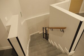 Una escalera con barandilla y pasamanos de metal negro.