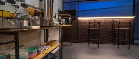 A modern kitchen with a brick wall, a bar area with stools, and a window with a view.
