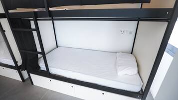 Een stapelbed met een witte matras en een zwart frame.