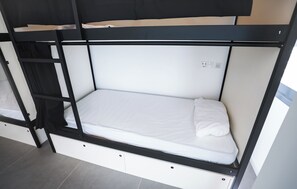 Una cama litera con colchón blanco y estructura negra.