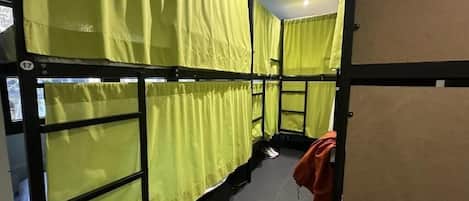 A room with bunk beds, a door, and a wall with a number.