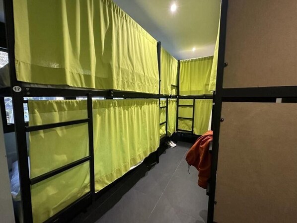 Una habitación con literas, una puerta y una pared con un número.