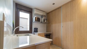 Una cocina compacta equipada con microondas, tostadora y estufa.