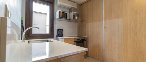 Una cocina compacta equipada con microondas, tostadora y estufa.