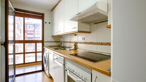 A kitchen with a built-in oven, a microwave, and a sink.