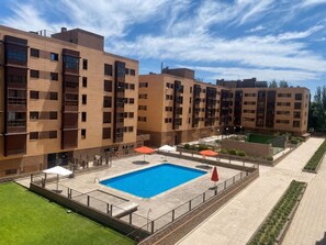Un immeuble dâappartements moderne dotĂ© dâune piscine, dâun espace extĂ©rieur amĂ©nagĂ© et dâune pelouse bien entretenue.