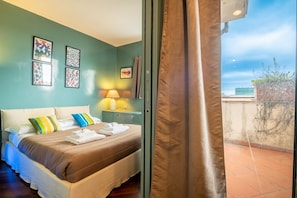 Une chambre d’hôtel avec un lit, une table de chevet, une lampe et une vue sur l’extérieur.