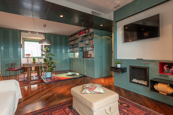 Un salon avec un canapé, un pouf et une cheminée.
