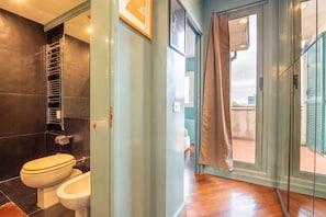 Une salle de bain équipée de toilettes, d’un bidet et d’un porte-serviettes.