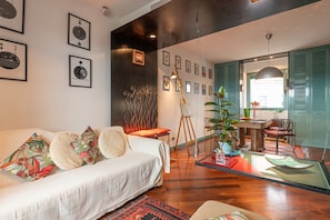 A modern living room with a sofa, coffee table, and artwork on the walls.