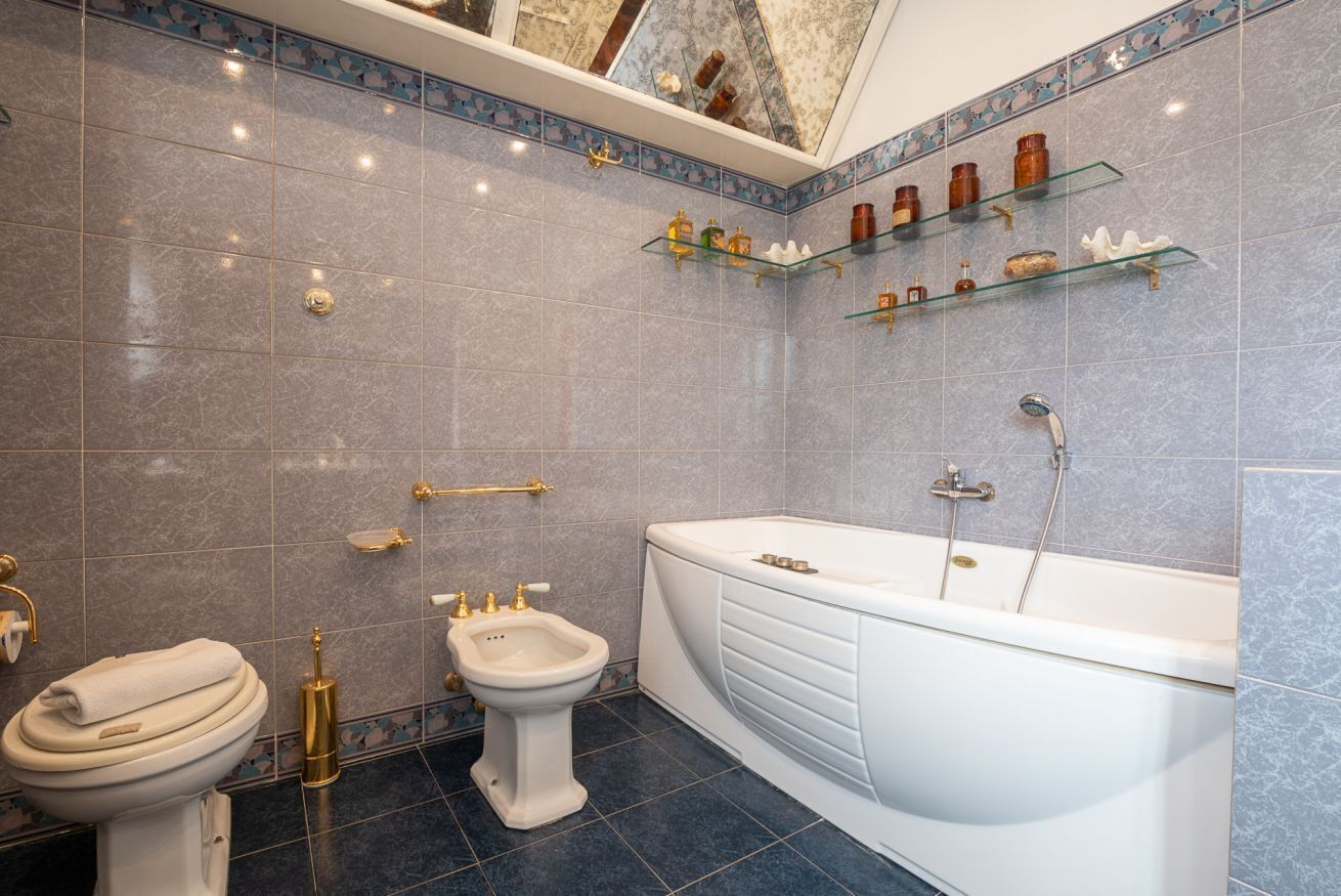 Ein Badezimmer mit Badewanne, Bidet, Toilette und Ablagen für Toilettenartikel.