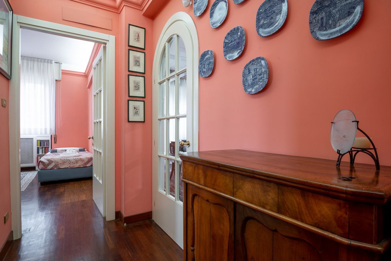 Una habitación con un aparador de madera, una puerta con paneles de vidrio y una pared decorada con platos azules.