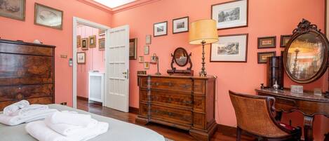 Un dormitorio con cama, cómoda, silla, escritorio y espejo.
