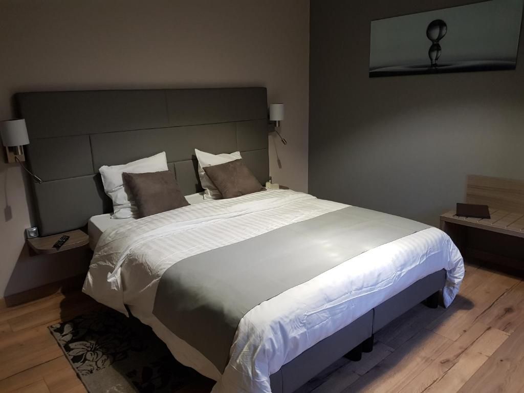 A modern bedroom with a large bed, two bedside tables, and a wall-mounted TV.