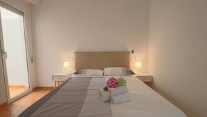 Ein Hotelzimmer mit einem großen Bett, zwei Nachttischen und einer Schiebetür.