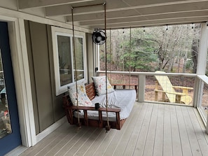 A wooden deck with a swing chair, a fan, and a view of the outdoors. - Blue Ridge Riverfront Cabin•2-Level Deck•Sleeps 8 (Blue Ridge)
