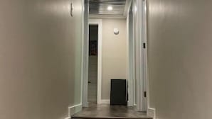 A narrow, well-lit hallway with a modern staircase leading to a door. - Blue Ridge Riverfront Cabin•2-Level Deck•Sleeps 8 (Blue Ridge)