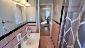 Une salle de bain équipée d’un lavabo, d’un miroir, d’un porte-serviettes et d’un rideau de douche.
