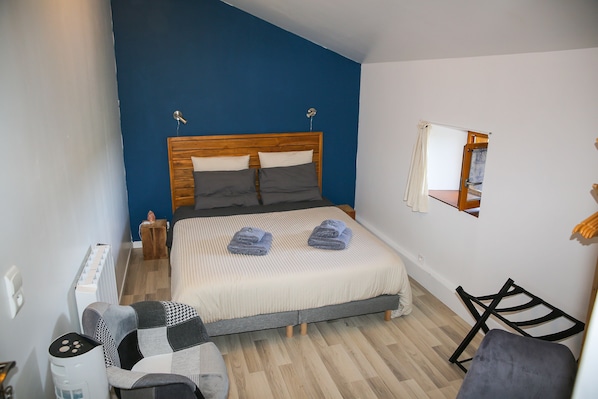 A bedroom with a bed, a chair, a small table, and a mirror on the wall. - Cadol'Ain (Servignat)
