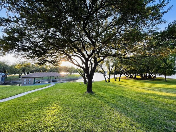 A park with a large tree, a pavilion, and a body of water in the background. - Shorhaus, Gorgeous Main Body Lake Retreat (Granbury)