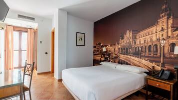 Habitación de hotel con una cama grande, un escritorio con silla, un teléfono y un mural en la pared que muestra un edificio.