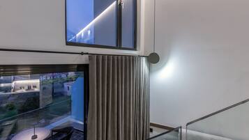 Una habitación moderna con balcón, una mesa con sillas y un sofá.