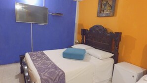 A bedroom with a bed, a television, a nightstand, and a small white cabinet. - Hotel Boutique Royal Palm Inn (San Andrés)
