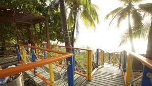 A wooden bridge with blue and orange railings, leading to a covered area with a metal bucket and rope. - Hotel Boutique Royal Palm Inn (San Andrés)