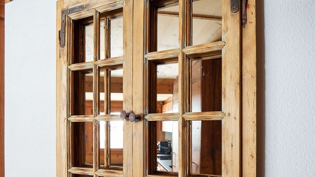 Una puerta de madera con cuadros de vidrio y un pestillo de metal.