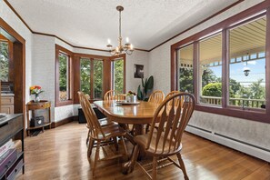 Dining room with round table & bay windows in lake light - Grammy's Lake House on Lake Pocotopaug (East Hampton)